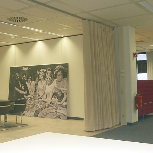 Meeting room with acoustic curtain and large painting with casino scene