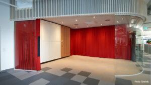 Red acoustic curtain to separate the meeting island in the office