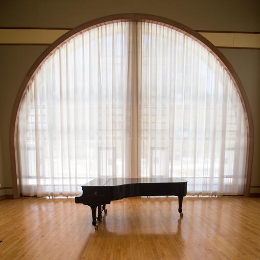 Sash in front of round-arched window with acoustic curtain