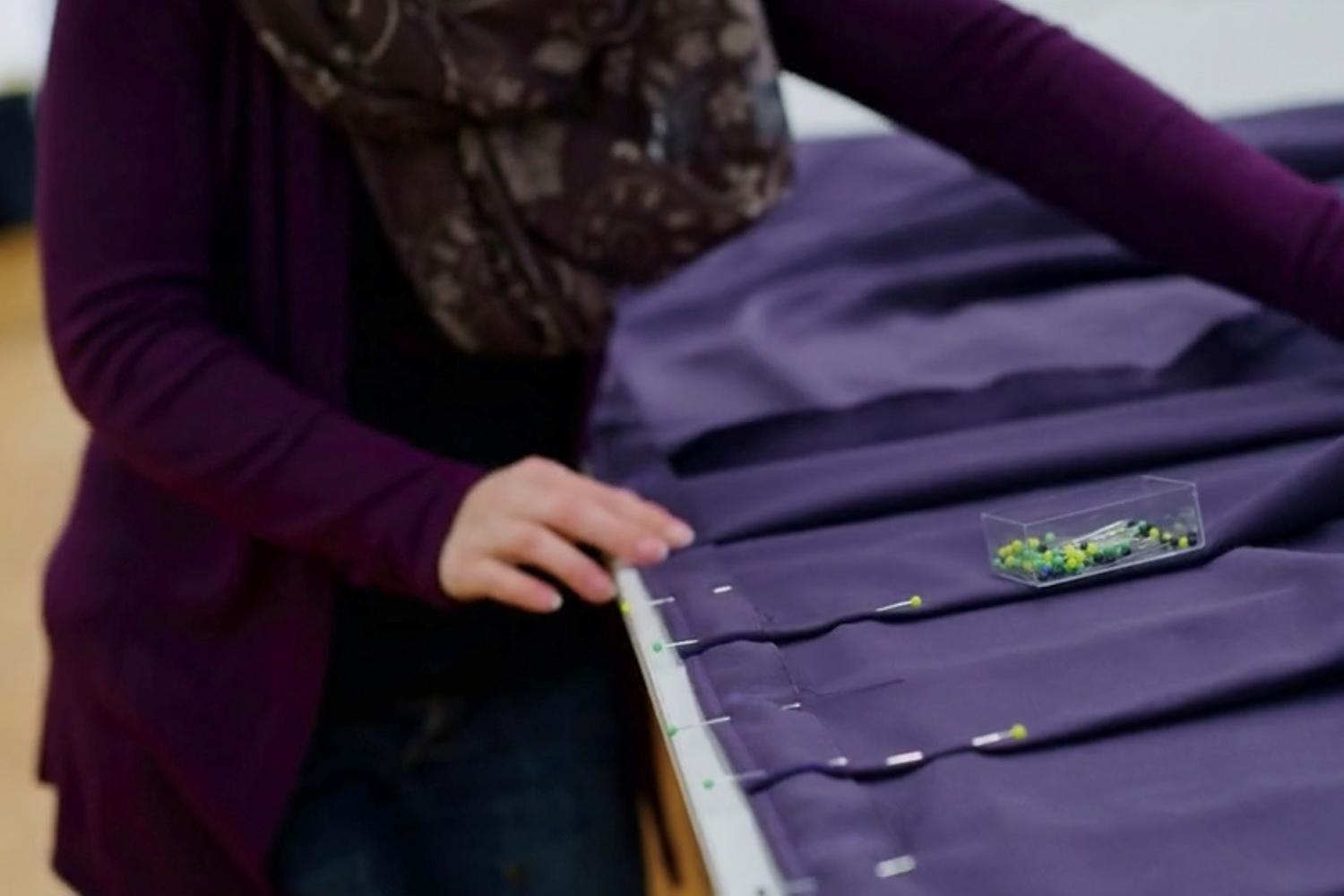 Une couturière délimite des bandes de tissu