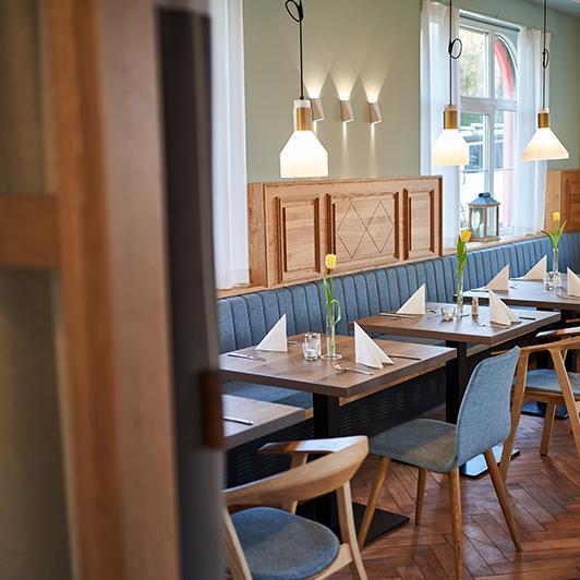 Tables in restaurant with curtains made of acoustic fabric