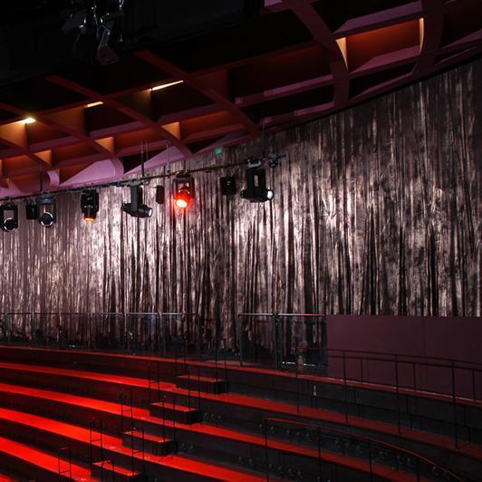 Illuminated rows of seats with surrounding silver curtains