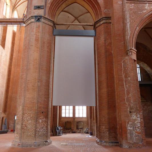Pancarta acústica enrollable en una iglesia gótica de ladrillo